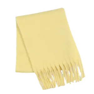 Detailaufnahme des weichen gelben Winterschals mit zarter Fransenstruktur und feinem Strick.