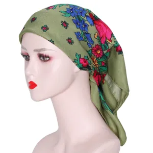 Detail view of the green Russian ethnic floral headscarf, showing rich pattern and fabric texture.