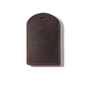 Vintage crazy horse leather luggage tag detail, dark brown texture, durable contrast stitching.