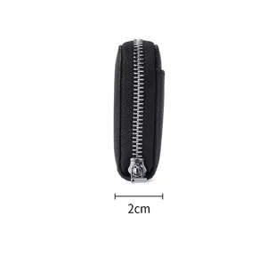 Minimalist black leather coin purse side view with silver zipper detail, 2cm thickness.