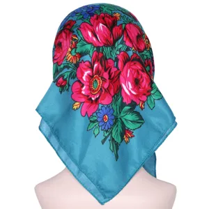Detail view of the ethnic floral square headscarf with vibrant red roses on blue fabric.