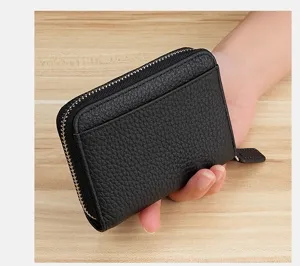 Close-up detail of black leather card holder, showcasing fine texture and neat zipper.