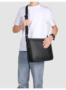 Black leather messenger bag detail, casual shoulder bag showing fine strap craftsmanship.