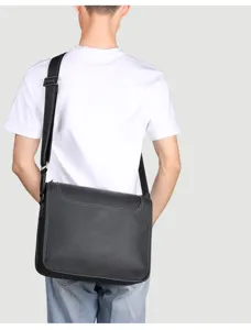 Detail view of genuine leather messenger bag back wear, casual style black cross body strap.