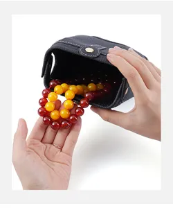 Black genuine leather jewelry storage box pouch with colorful beaded bracelets inside.