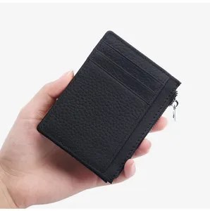Close-up view of black leather cardholder showing card slots and smooth zipper pocket.