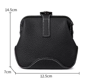 Genuine leather kiss-lock cosmetic bag detail showing compact size and fine pebble grain texture.