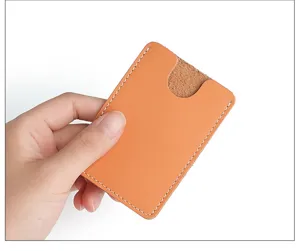 Gros plan sur le porte-carte en cuir orange mince montrant de belles coutures et texture.
