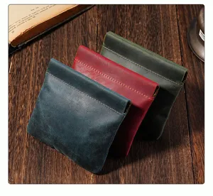 Close up of vintage genuine leather coin purse with spring frame, detail view on wooden table.