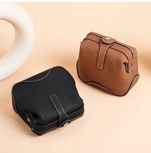 Detailed view of genuine leather cosmetic storage bag featuring clasp and snap button closure.