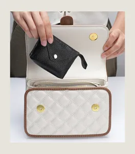 Detail view of a genuine leather mini coin purse placed inside a quilted handbag.