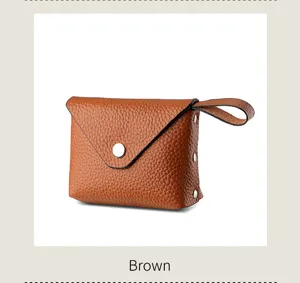 Brown mini leather coin purse with flap snap button and convenient wrist strap detail.