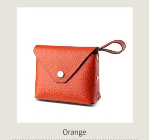 Mini orange leather coin purse with snap closure and wrist strap, compact zipper wallet for women.