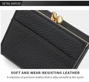 Detail shot of black genuine leather women's three-fold wallet with kiss-lock clasp.