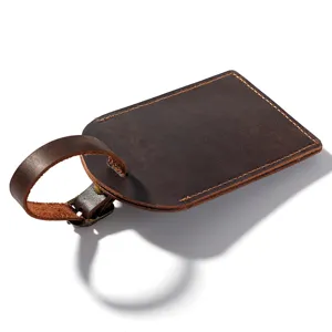 Vintage brown leather luggage tag with secure buckle strap, ideal for travel bags.