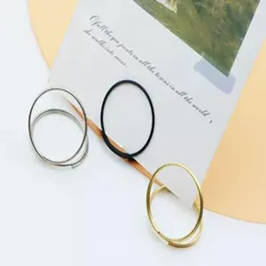 Detail shot of metal double-circle memo clips and card holders on a decorated desk surface.