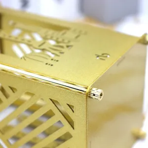 Golden metal pen holder detail, hollow design with screw assembly, textured surface close up