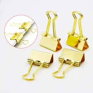 Golden binder clips detail view showing secure paper binding and metallic finish texture.