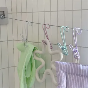 Detailed view of colorful metal hook clips hanging on wire, perfect for bathroom storage.