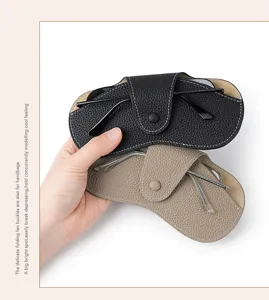 Vista detallada de la bolsa de cuero genuino para gafas con diseño de botones de presión.