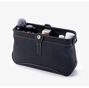 Premium leather cosmetic bag detail, soft litchi texture, contrast stitching, large capacity.