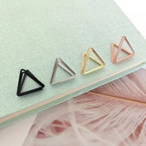 Close-up detail shot of metal triangle paper clips in black silver gold and rose gold.