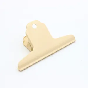 Close-up detail shot of a large metal bulldog clip in creamy yellow, ideal for office and art.