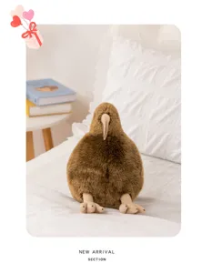 Detailed view of the cute simulation kiwi bird plush toy sitting on a cozy white bed.