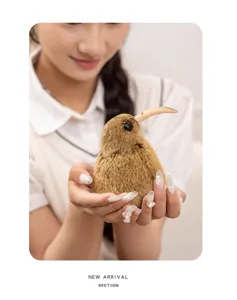 Close-up detail shot of a cute simulated kiwi bird plush toy held gently in hands.