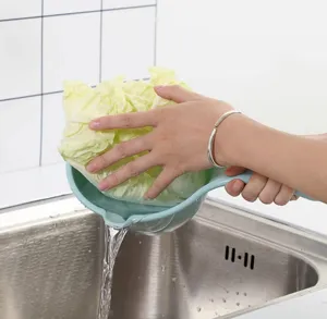 Détail de la loupe d'eau en plastique avec un long manche dans l'évier de cuisine.