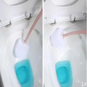 Detail view of a pink handle toilet brush with white bristles cleaning a white toilet bowl.
