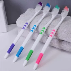 Soft bristle toothbrush set with colorful handles, displayed neatly on a grey towel daily care.