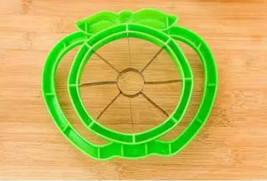 Gros plan détail du coupe-fruits trancheuse de pommes en plastique vert inox.