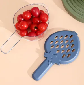Vue détaillée du panier d'égouttage de cuisine en forme de fraise avec cuillère et couvercle.