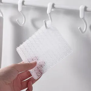 Detalle de cerca del cepillo flexible y transparente para verduras con superficie texturizada.