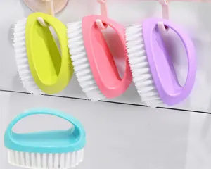 Detail view of colorful plastic laundry shoe brushes with white bristles hanging and placed.