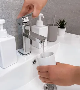 Detailaufnahme eines minimalistischen weißen Mundspülbechers in einem modernen Badezimmer.