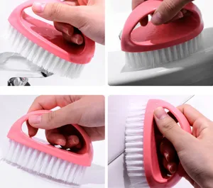 Detail shot of a pink egg-shaped cleaning brush with white bristles for scrubbing shoes and clothes.