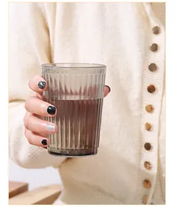 Smoky gray mouthwash cup close-up, elegant vertical stripes for modern bathroom use.