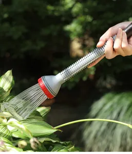 Dettaglio in primo piano della lancia per tubo flessibile da giardino che bagna le piante.