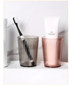 Detailed close-up of fluted plastic mouthwash cups in grey and pink, perfect for bathroom sink decor.