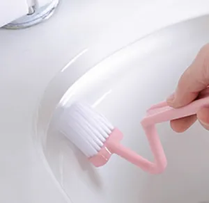 Detailed view of the pink S-shaped curved cleaning brush showing soft bristles in use.