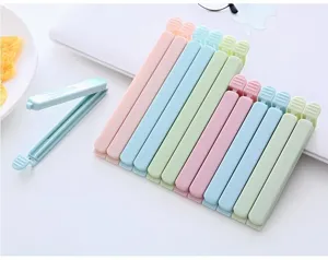 Detailed close-up of colorful plastic food sealing clips arranged neatly on a white table.