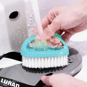 Multifunctional egg-shaped shoe cleaning brush with soft white bristles for home laundry use.