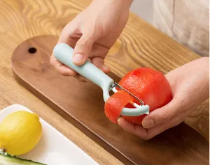 Éplucheur de fruits et légumes multifonctionnel domestique vue détaillée avec poignée.