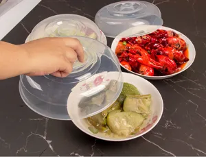 Close-up view of transparent plastic microwave food cover in use on dishes, heat resistant.