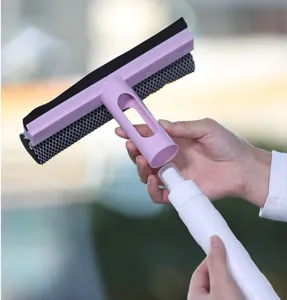 Nahaufnahme von Händen beim Zusammenbau eines rosa Fensterwischers mit Sprühflasche.