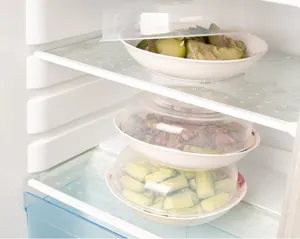 Transparent microwave food cover detail showing stacked plate lids inside refrigerator storage.