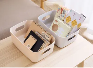 Panier de rangement de bureau en plastique avec poignées pour papeterie, snacks et cosmétiques.