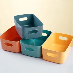 Vue détaillée de paniers de rangement en plastique coloré avec poignées, idéaux pour le bureau.